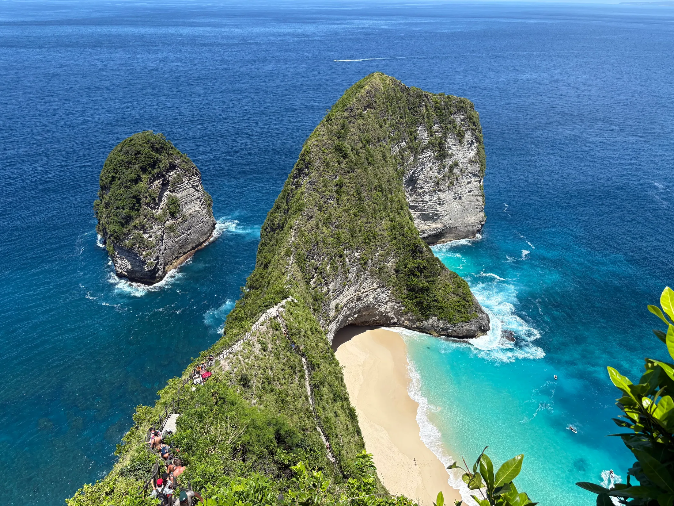 Kelingking beach on Nusa Penida from the clifftop, the headland running down to white sand and turquoise water