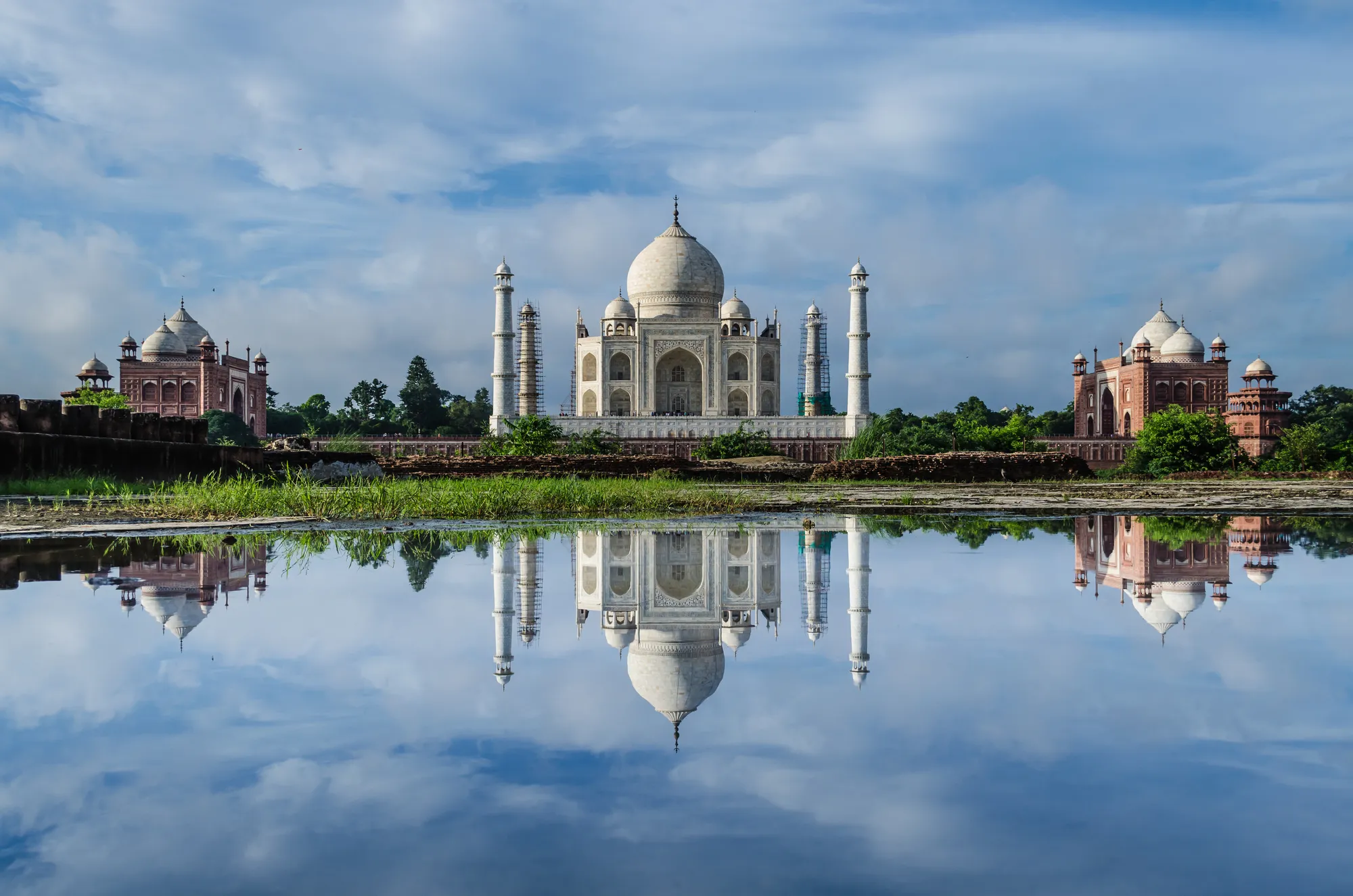 A white domed mausoleum mirrored in still water
