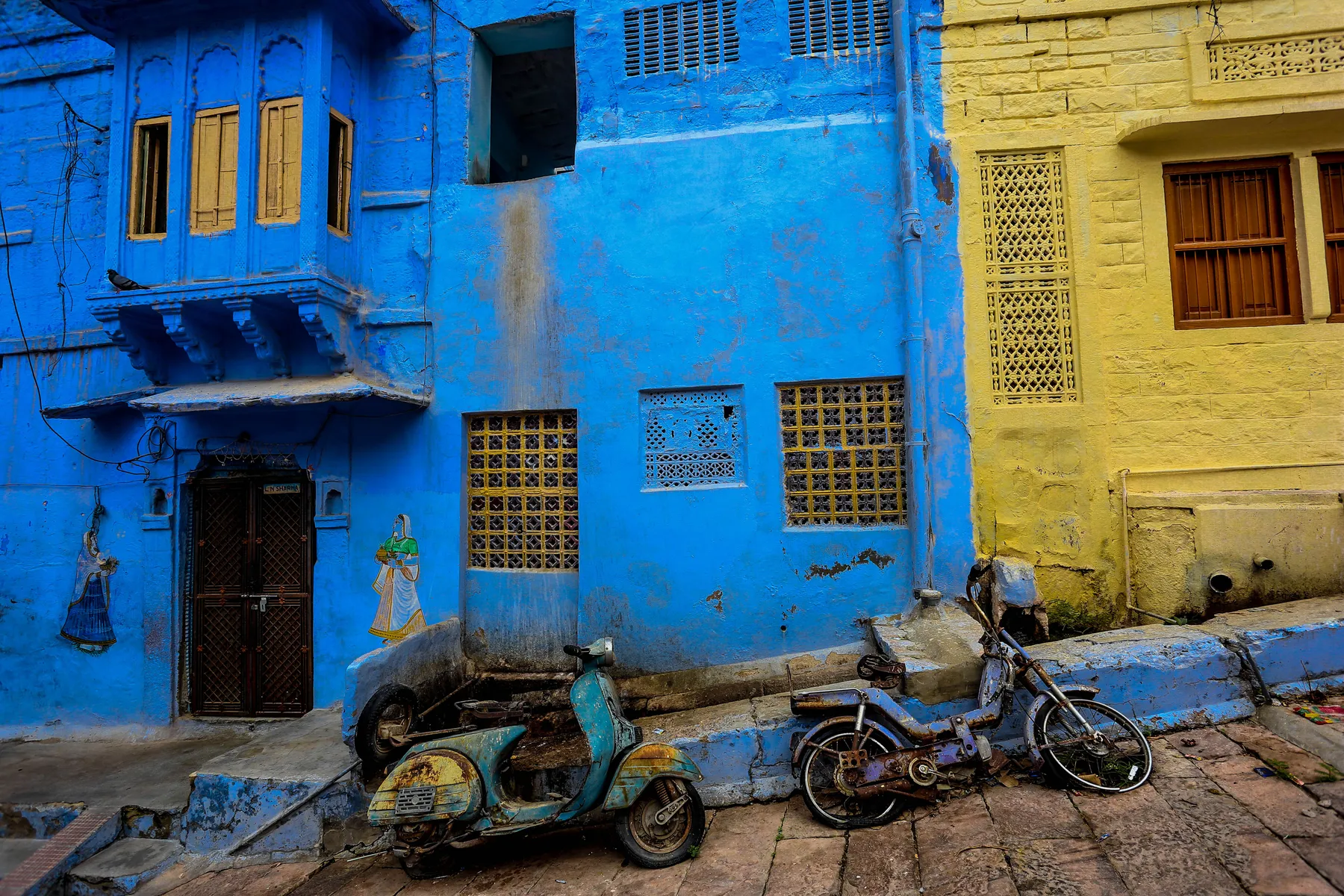 A blue-washed lane with a carved doorway