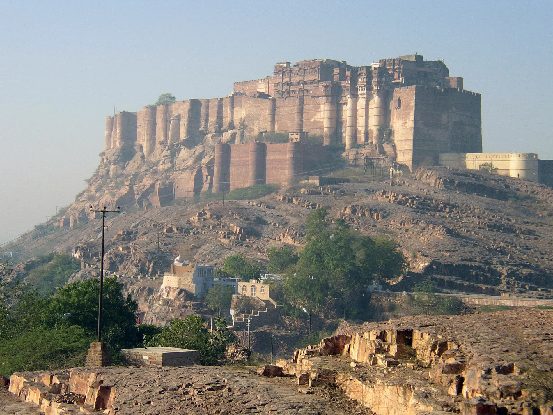 A large fort on a rocky outcrop above a town