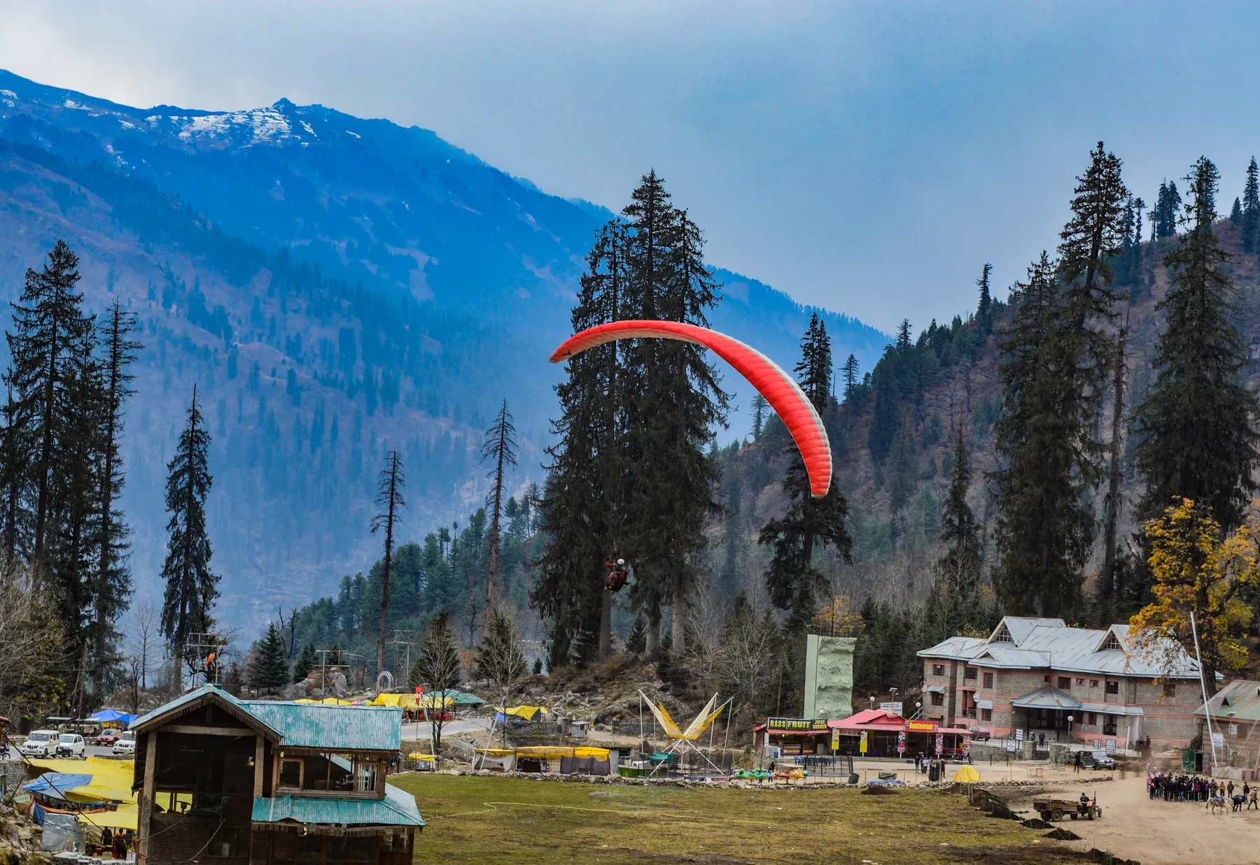 A paraglider above a wide mountain valley